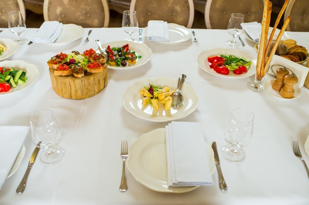 Dishes and serving on a laid banquet table and served on oak slices on a table