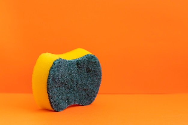 Dishwasher sponge on orange background