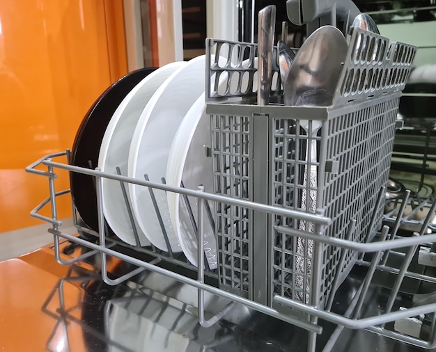 Dishwasher with open dishes in kitchen closeup