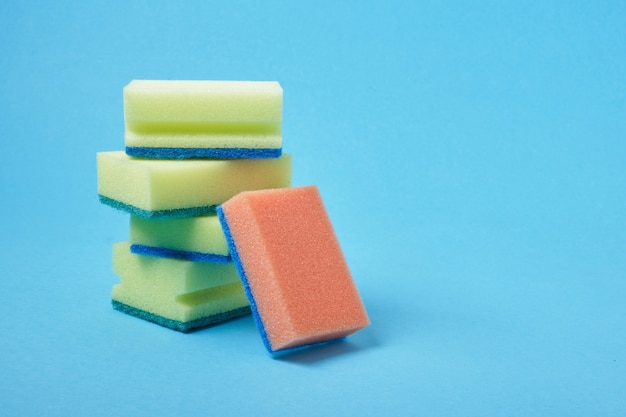 dishwashing sponges on blue background copy space cleaning concept