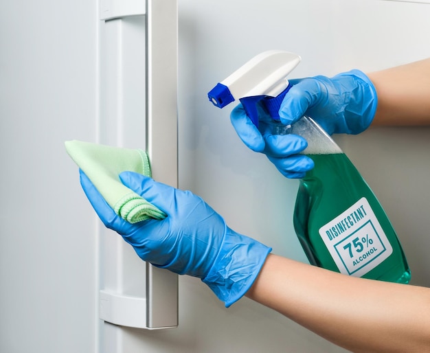 Foto disinfezione della porta del frigorifero durante una pandemia di coronavirus. pulisci la maniglia della porta del frigorifero. pulizia sterile in casa.