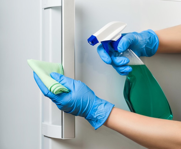 Photo disinfection of the refrigerator door during a coronavirus pandemic