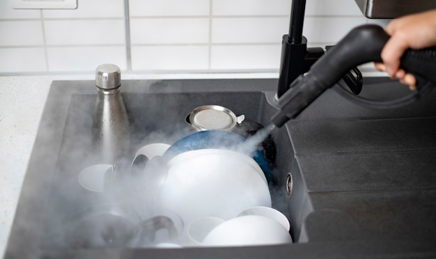 Disinfezione e sanificazione della casa, stoviglie fumanti nel lavello della cucina