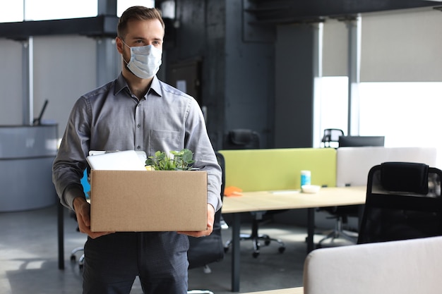 전염병 코로나바이러스 covid-19의 해고 직원. 사무실에서 사무용품을 들고 출근하는 해고된 노동자