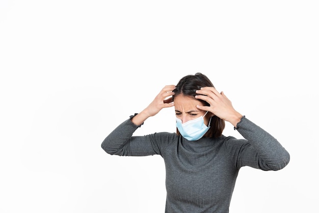 Dispaired hispanic woman wearing a surgical face mask