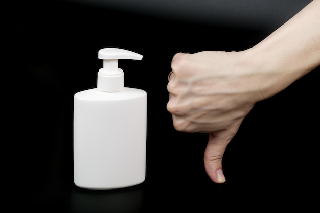 Dispenser with disinfectant and a mask on a black background.Closeup