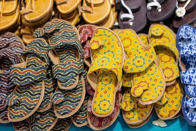 A display of colorful sandals with a yellow pattern on the front.