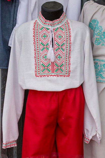 Display of embroidered Ukrainian slavic men traditional shirts embroidery clothing in outdoor flea market in Lviv Ukraine Close up Ethnic texture design on the cloth