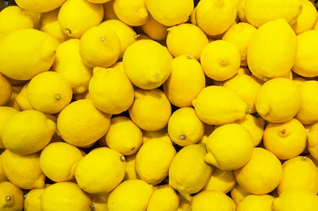 Display of fresh lemons in the grocery store market texture photo pile