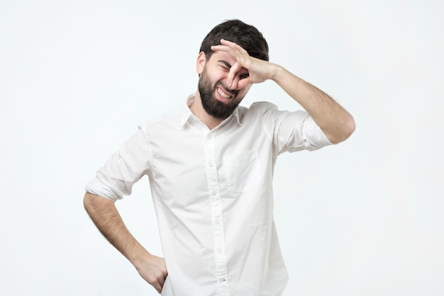 Displeased brunet male plugs nose as smells something stink and unpleasant