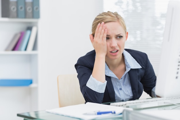 Displeased business woman at office desk