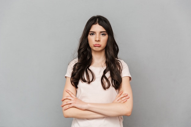 Displeased sad young lady standing isolated