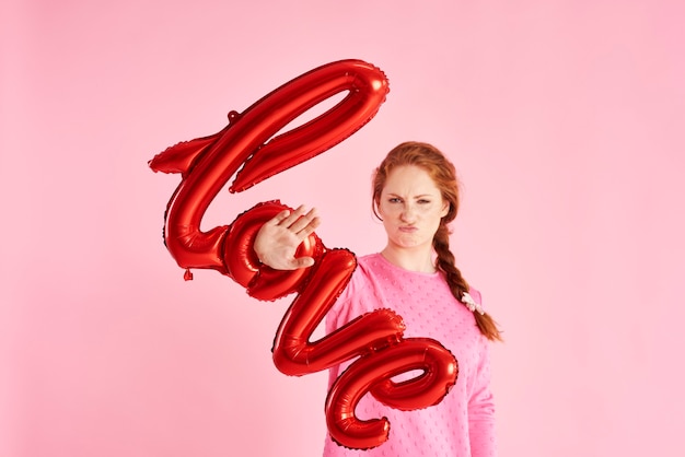 Displeased woman showing stop sign at studio shot