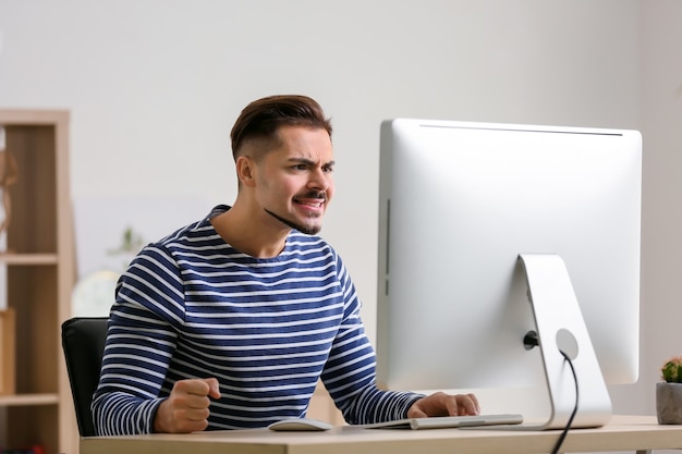 Displeased young man after losing computer game at home