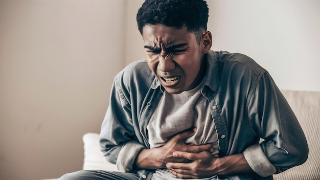 Displeased young man with painful feelings holding belly