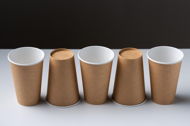 Disposable cardboard biodegradable cups on a white table gray background