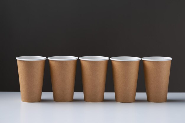 Disposable cardboard biodegradable cups on a white table gray background