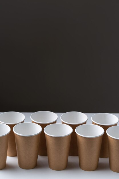 Disposable cardboard biodegradable cups on a white table gray background