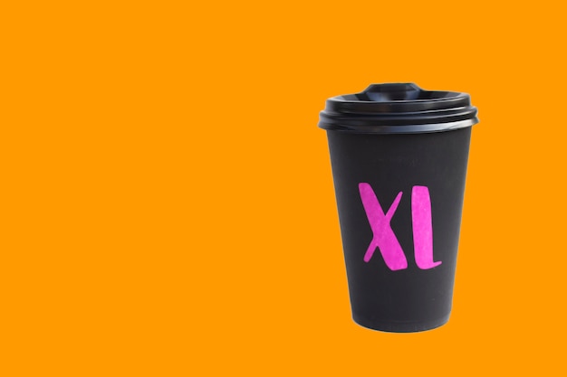 Disposable cardboard black cup isolated on orange background, eco cup for hot drinks, autumn mood