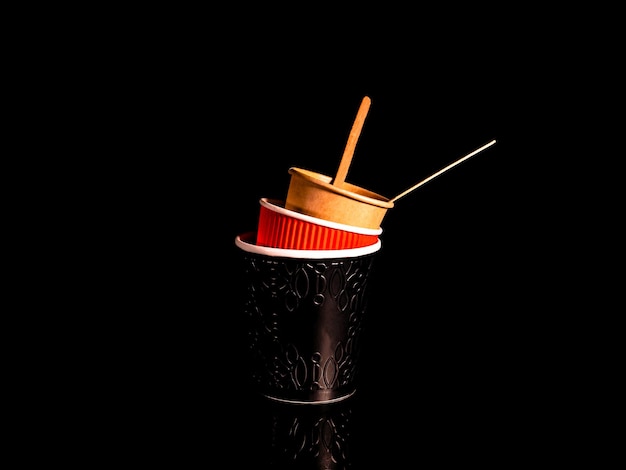 Disposable cardboard coffee cups on a black background