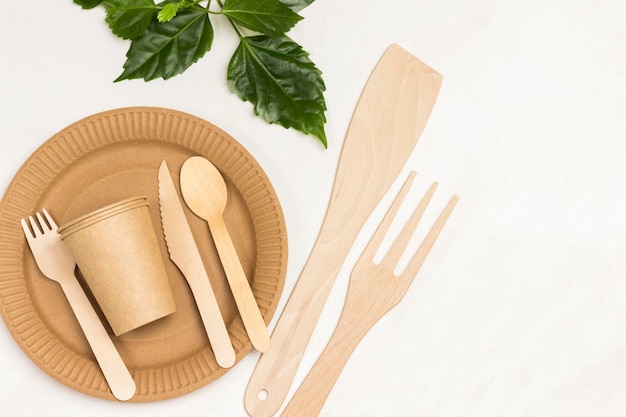 Disposable cardboard dishes Wooden forks and spoons Ecofriendly dish White background Flat lay