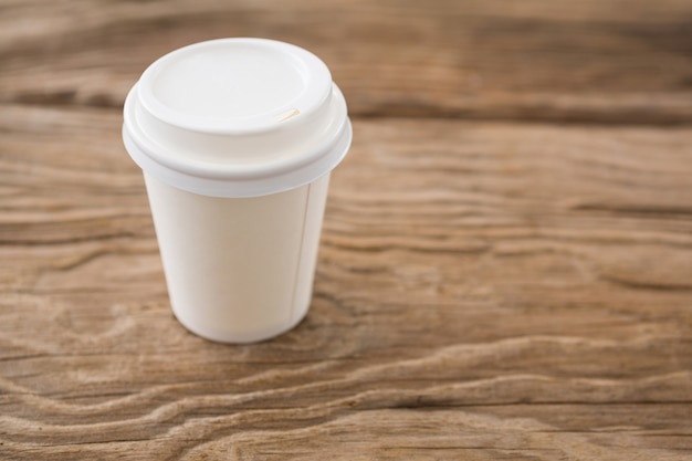 Disposable coffee cup on wooden table