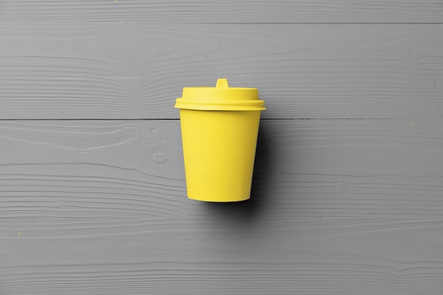 Disposable coffee cup in yellow gray colors