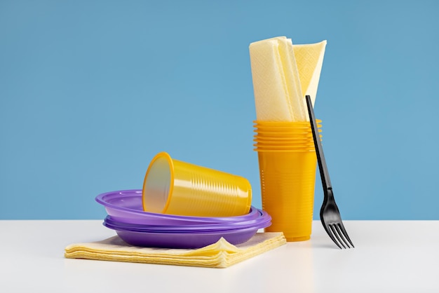 Disposable colorful plastic tableware and paper napkins, studio
shot.