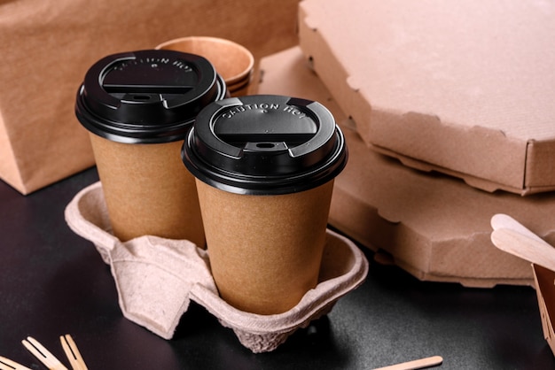 Disposable dishes made of environmentally friendly brown cardboard on a dark background. food delivery in disposable dishes
