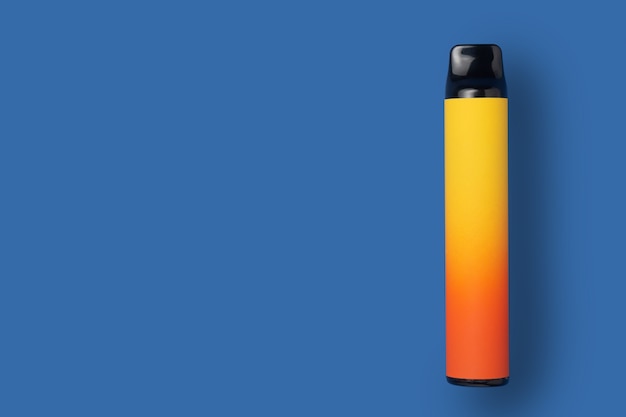 Фото Одноразовые электронные сигареты желтого цвета градиента на синем изолированном фоне. концепция современного курения, вейпинга и никотина. вид сверху