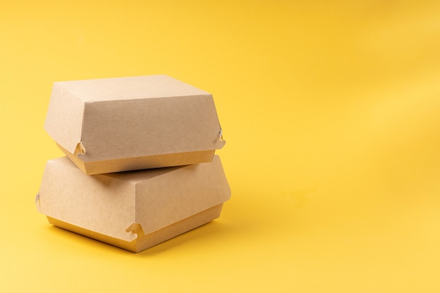 Disposable food delivery boxes on yellow background