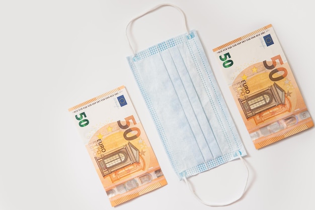 disposable hygienic face mask and two fifty euro banknotes