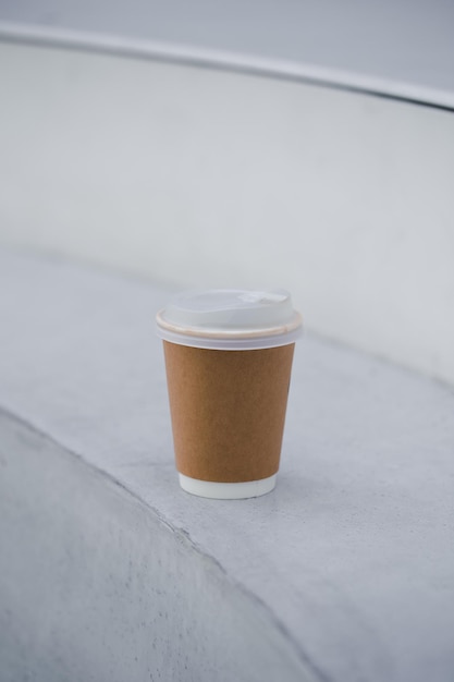 Disposable paper coffee cup on a wooden table at cafe