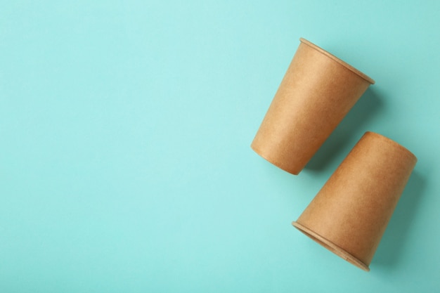 Disposable paper cups on mint background. Coffee concept.