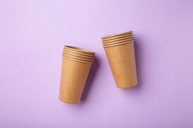 Disposable paper cups on purple background. Coffee concept.