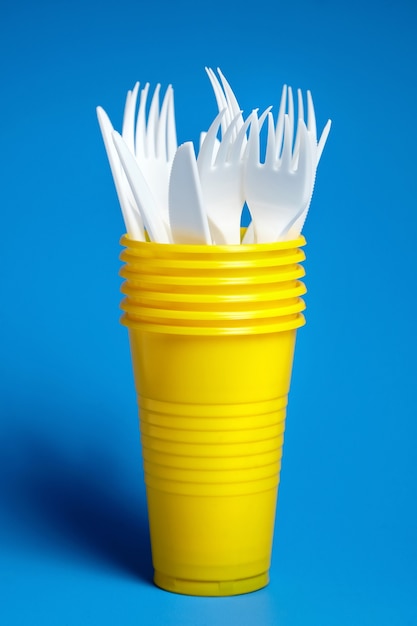 Disposable plastic tableware on blue