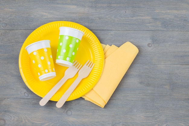 disposable plate, forks, disposable glasses and a napkin