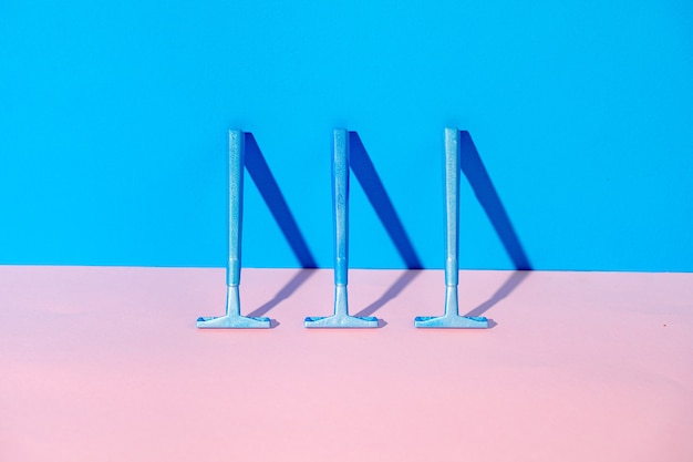 Disposable razor on blue and pink background, studio shot