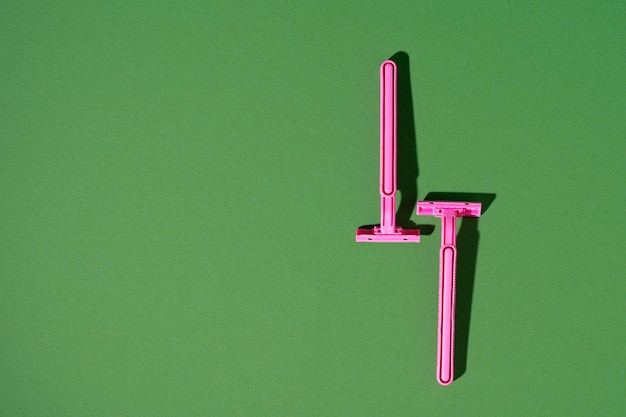 Disposable razor on green background, studio shot