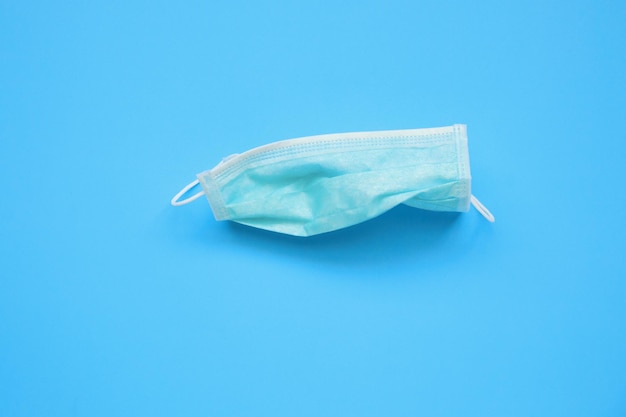 Disposable surgical face mask on blue background