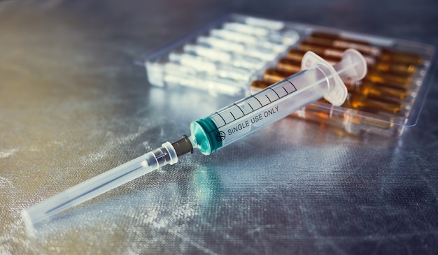 Disposable Syringe And Ampoules on a silver space, inscription single use only, shallow depth of sharpness