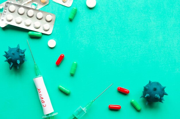 Disposable syringes and pills on green background Chinese Coronavirus disease covid19