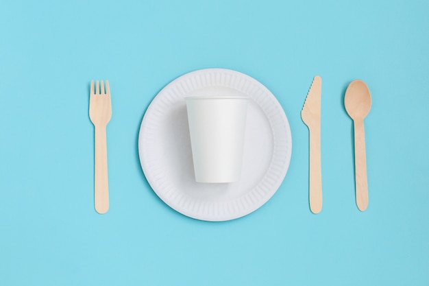 Disposable tableware from natural materials on blue background. eco-friendly