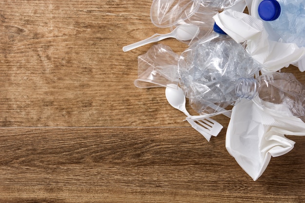 Disposable waste plastic on wooden, top view