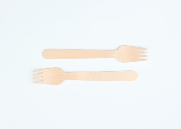 Disposable wooden forks on a white background. Cutlery made from natural materials