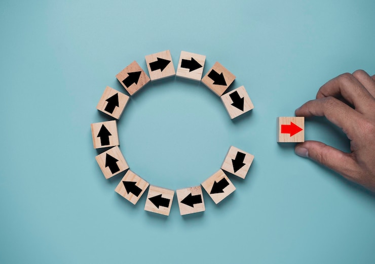 Photo disruption and technology transformation concept , hand move out red arrow on wooden block cube move out from circle black arrow on blue background.