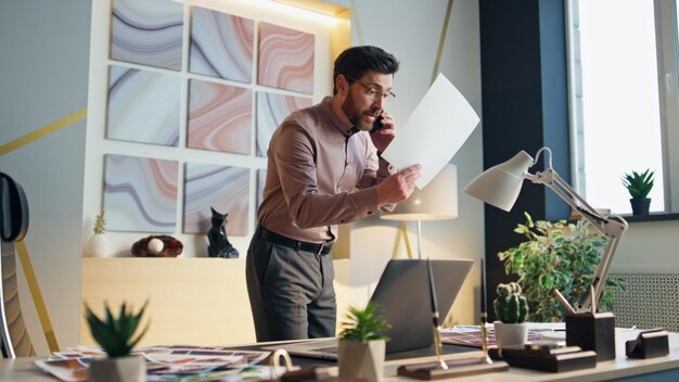 Photo dissatisfied ceo arguing phone standing office workplace business man calling