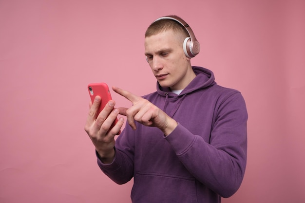 dissatisfied guy wearing headphones and pointing at his phone