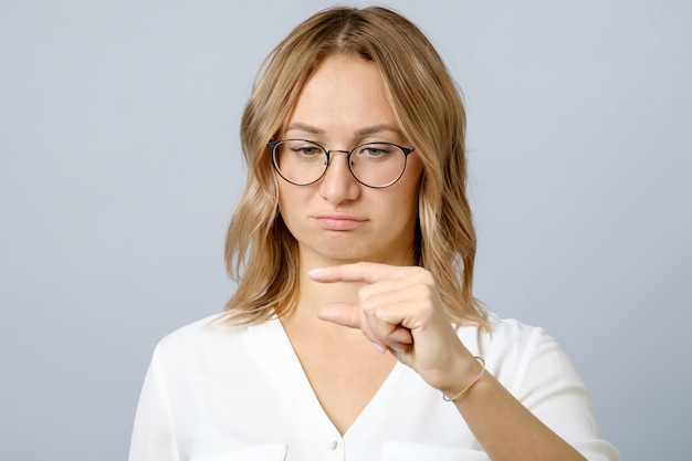 Dissatisfied young woman demonstrates something little