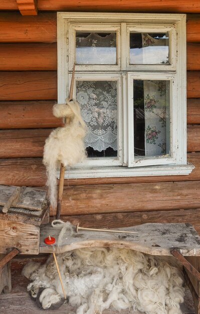 Фото Прялка у окна старого дома